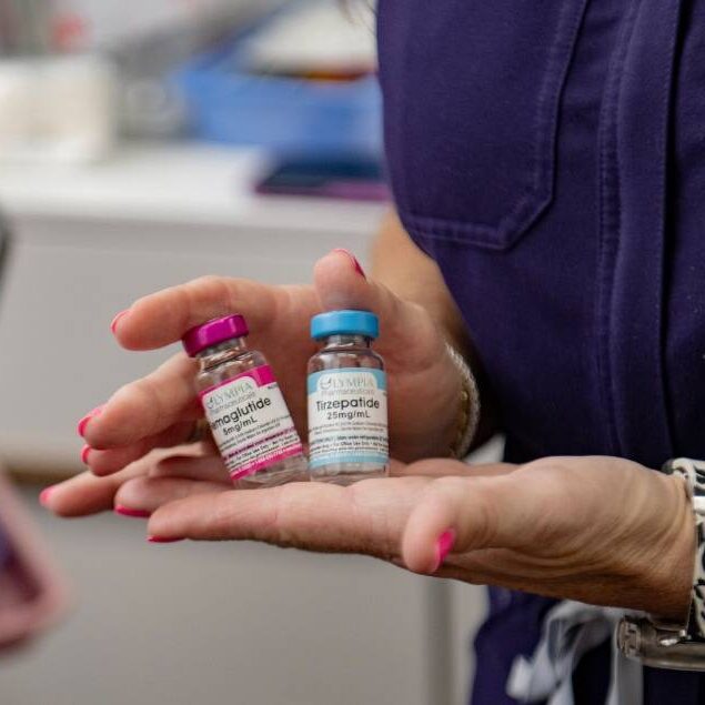 Hands holding glp-1 medication vials